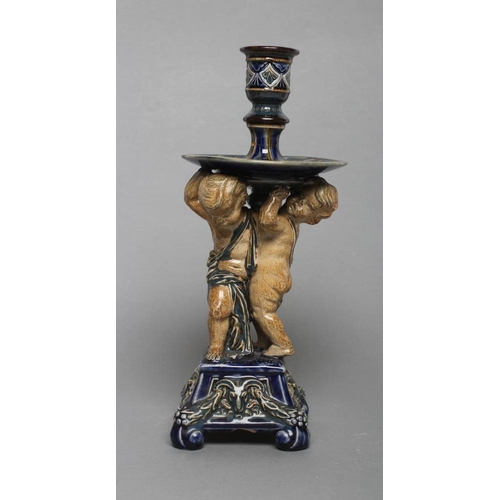 70 - A STONEWARE FIGURAL CANDLESTICK, probably designed by George Tinworth for Doulton Lambeth, the reel ... 