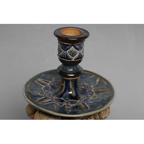 70 - A STONEWARE FIGURAL CANDLESTICK, probably designed by George Tinworth for Doulton Lambeth, the reel ... 