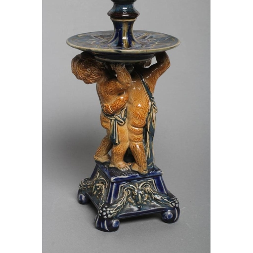 70 - A STONEWARE FIGURAL CANDLESTICK, probably designed by George Tinworth for Doulton Lambeth, the reel ... 