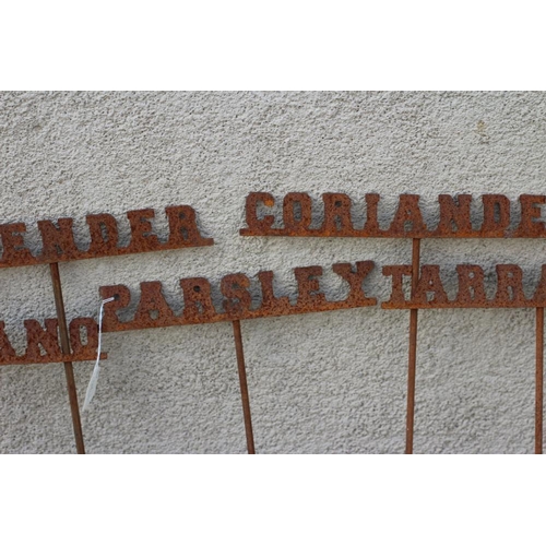 489 - A SET OF TEN RECLAIMED METAL HERB LABELS, each on a turned post with rust patination, 6