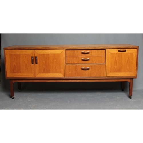 586 - A TEAK LONG SIDEBOARD BY G PLAN, mid 20th century, with formosa teak trim and loop handles, comprisi... 