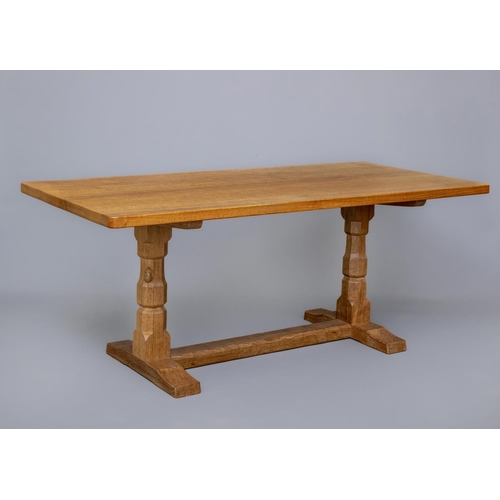 589 - A ROBERT THOMPSON ADZED OAK DINING TABLE, the rounded oblong plank top raised on turned faceted tres... 