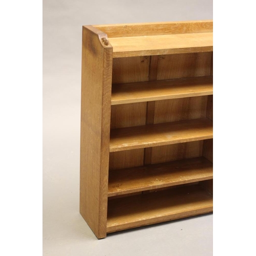 599 - A ROBERT THOMPSON ADZED OAK OPEN BOOKCASE of oblong form with three quarter galleried top, three adj... 