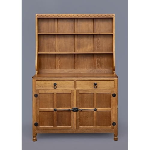 600 - A ROBERT THOMPSON ADZED OAK DRESSER, the boarded delft rack with half penny moulded cornice over sha... 