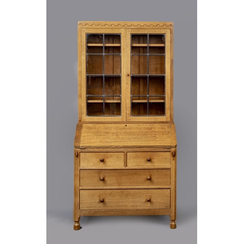 605 - A ROBERT THOMPSON ADZED OAK BUREAU BOOKCASE, the upper section with half penny moulded cornice over ... 