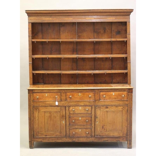 615 - A GEORGIAN OAK ENCLOSED DRESSER c.1800, the delft rack with moulded cornice over reeded frieze and t... 