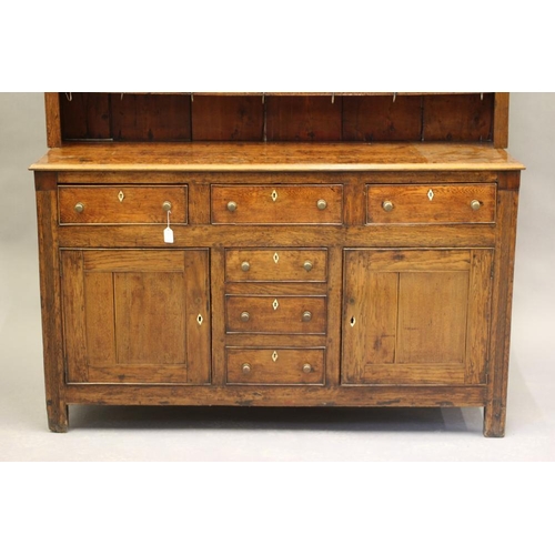 615 - A GEORGIAN OAK ENCLOSED DRESSER c.1800, the delft rack with moulded cornice over reeded frieze and t... 