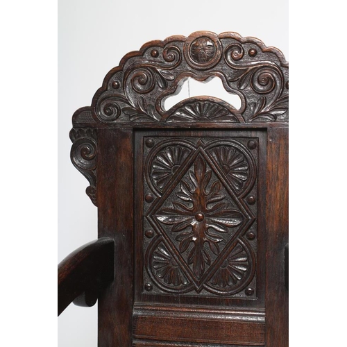 617 - A CHILDS JOINED OAK ARMCHAIR, in 17th style, the panelled back carved with foliage and surmounted by... 