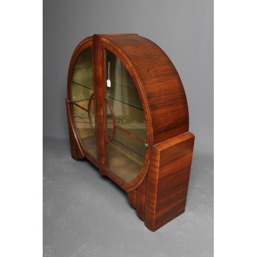 625 - AN ART DECO WALNUT DISPLAY CABINET of circular form with two astragal glazed doors with turned brass... 