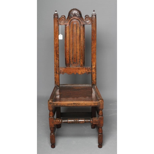 627 - A JOINED OAK BACKSTOOL, c.1700, the square uprights with pointed finials enclosing an arched leaf an... 