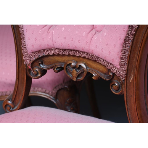 652 - A SET OF FOUR VICTORIAN WALNUT BALLOON BACK SALON CHAIRS button upholstered in a pink weave, the cha... 