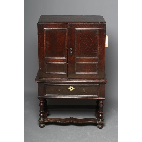 661 - AN OAK CHEST ON STAND, the chest with two twin panel doors enclosing a central cupboard and twelve s... 