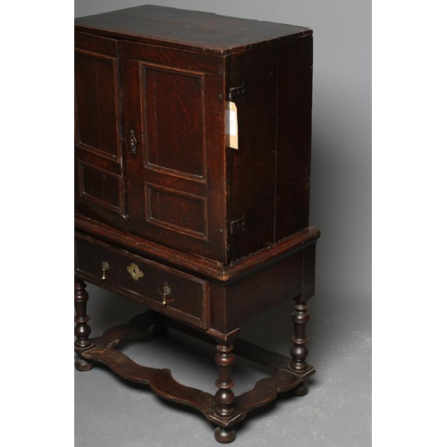 661 - AN OAK CHEST ON STAND, the chest with two twin panel doors enclosing a central cupboard and twelve s... 