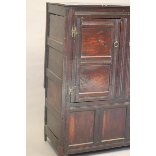 662 - AN OAK CLOTHES PRESS, c.1700, the moulded edged plank top over a pair of twin panel doors enclosing ... 