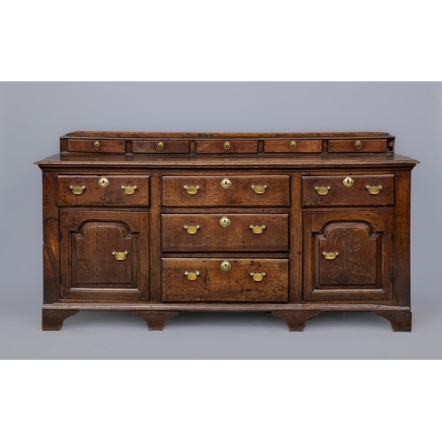 671 - A GEORGIAN OAK ENCLOSED DRESSER, third quarter 18th century, the moulded edged plank top with raised... 