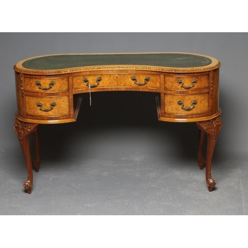 676 - A CARVED BURR WALNUT KIDNEY SHAPED DESK, early/mid 20th century, the carved and banded top inset wit... 