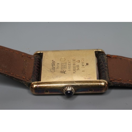 153 - A MUST DE CARTIER SILVER GILT WRISTWATCH, the dark red oblong dial with gilt metal hour and minute h... 