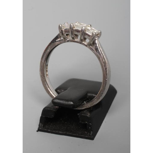 174 - A THREE STONE DIAMOND RING, the Princess cut stones point set to a plain platinum shank, size N (Est... 