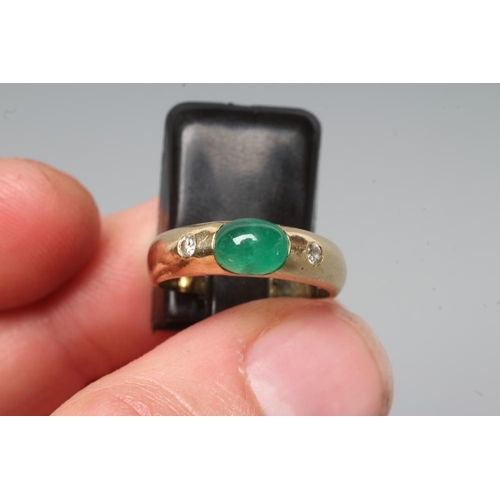 198 - AN EMERALD AND DIAMOND RING, the oval cabochon polished emerald tension set and flanked by two gypsy... 