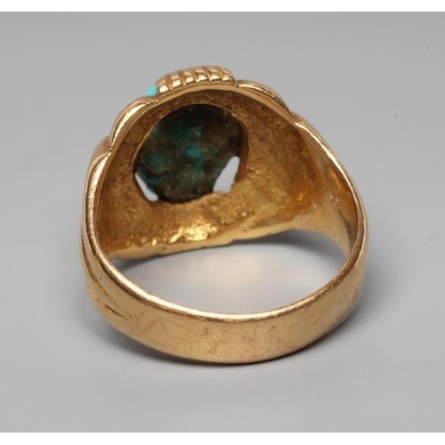 199 - A GENTLEMAN'S RING, the oval cabochon polished turquoise set to an open fancy surround and wide shan... 