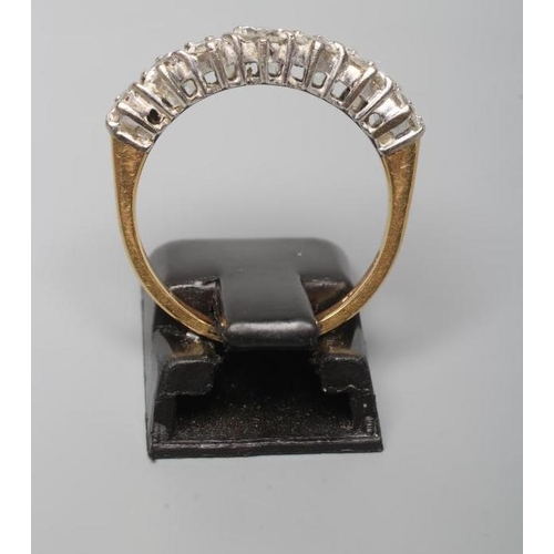 202 - A SEVEN STONE DIAMOND HALF HOOP ETERNITY RING, the round brilliant cut stones claw set to a plain 18... 