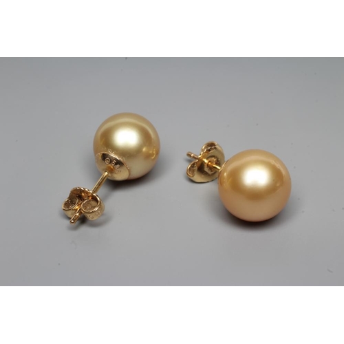 206 - A PAIR OF PALE GOLD COLOURED CULTURED PEARL EAR STUDS, peg set to plain posts, stamped 585 (Est. plu... 