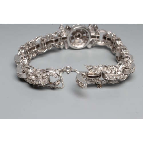 241 - A DIAMOND BRACELET, the central cluster with bow shoulders and open circular links and invisible hin... 