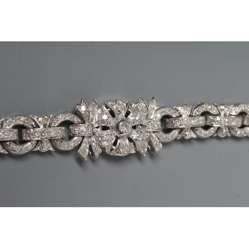 241 - A DIAMOND BRACELET, the central cluster with bow shoulders and open circular links and invisible hin... 