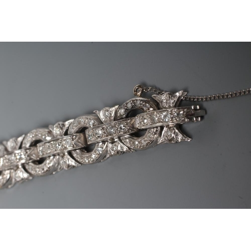 241 - A DIAMOND BRACELET, the central cluster with bow shoulders and open circular links and invisible hin... 