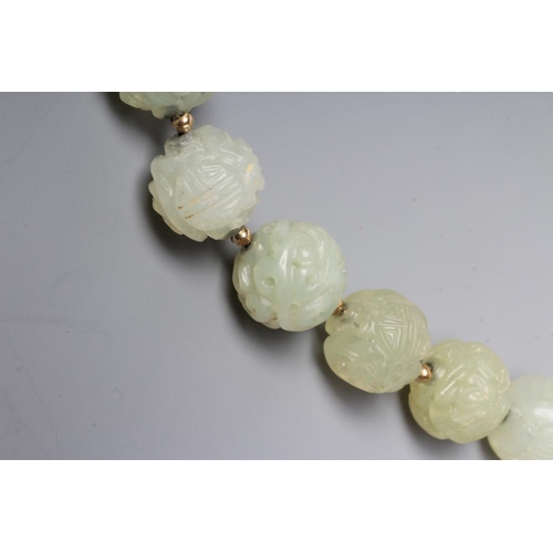 253 - A STRING OF CHINESE CELADON JADE BEADS, the forty six spherical beads carved with scroll and flowers... 