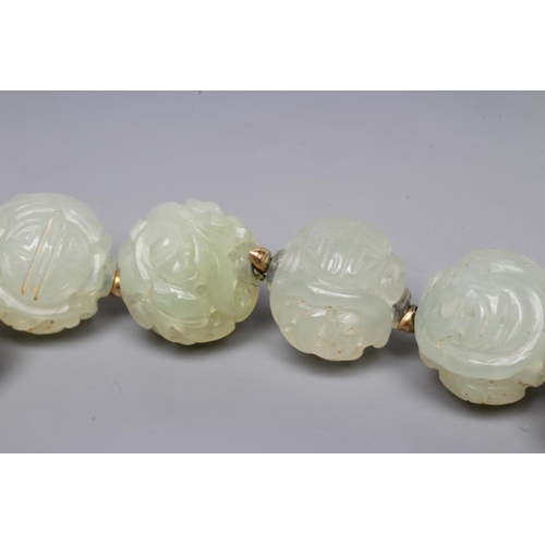 253 - A STRING OF CHINESE CELADON JADE BEADS, the forty six spherical beads carved with scroll and flowers... 