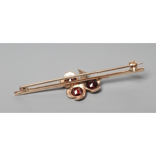 261 - A SHAMROCK BAR BROOCH set with three facet cut circular garnets with small diamond centre and stem, ... 