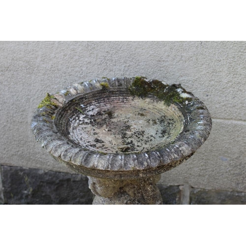 525 - A HADDONSTONE BIRD BATH, the moulded circular bowl with ovolu rim held aloft by three putti, on moul... 