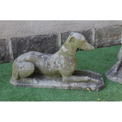 531 - A PAIR OF CAST STONE RECUMBENT GREYHOUNDS on canted oblong bases, 27