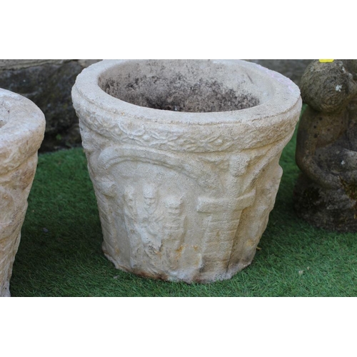 543 - A PAIR OF CAST STONE PLANTERS of circular tapering form, modelled with a band of figures beneath arc... 