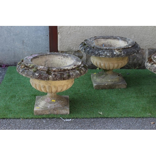 546 - A SET OF SIX CAST STONE URNS of low half fluted campana form with ovolu moulded rims, on waisted soc... 