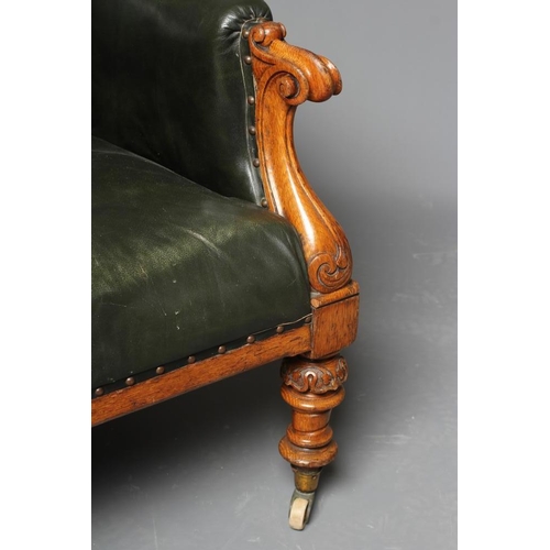 659 - AN MID VICTORIAN OAK FRAMED ARMCHAIR button upholstered in green leather, channelled scroll back upr... 