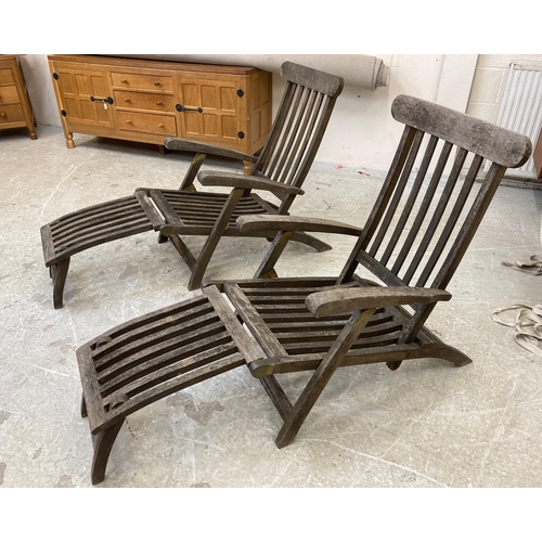 492 - A PAIR OF SLATTED TEAK STEAMER ARMCHAIRS with brass fittings and green weather-proof loose cushions,... 