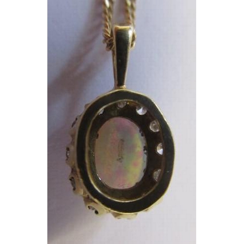 236 - AN OPAL AND DIAMOND CLUSTER PENDANT, the oval cabochon polished opal claw set to a border of small r... 