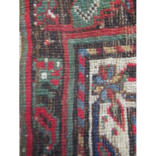 329 - A TURKISH PRAYER RUG, the green field with stepped red niche with flowers and candles, within a mult... 