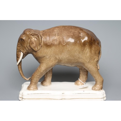 17 - A STAFFORDSHIRE POTTERY MODEL OF JUMBO, the elephant standing on a gilt lined shaped oblong base, 11... 