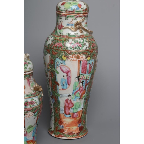 2 - THREE CANTONESE PORCELAIN FAMILLE ROSE VASES AND COVERS of inverted baluster form, all painted with ... 