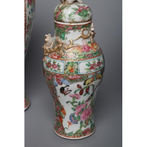 2 - THREE CANTONESE PORCELAIN FAMILLE ROSE VASES AND COVERS of inverted baluster form, all painted with ... 