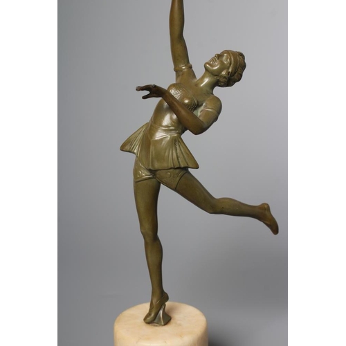 379 - AN ART DECO green patinated spelter figure in the style of Lorenzl, the young lady modelled standing... 