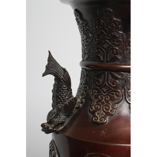 381 - A JAPANESE BRONZE VASE of cylindrical form with two dolphin handles, cast in relief with wading bird... 