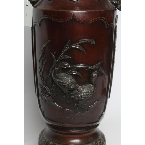 381 - A JAPANESE BRONZE VASE of cylindrical form with two dolphin handles, cast in relief with wading bird... 