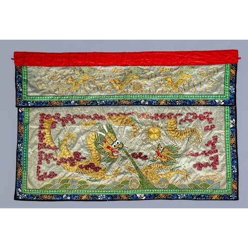 384 - A CHINESE WALL HANGING embroidered in coloured silks on a grey damask ground with two dragons chasin... 