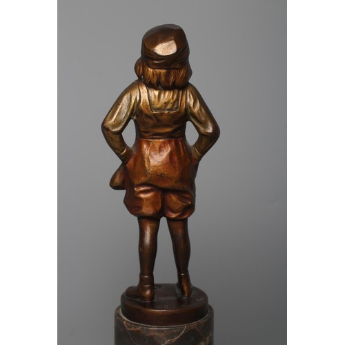 385 - B. GRUNDMANN - An Art Deco bronze figure cast as a young boy with carved ivory face wearing a cap on... 