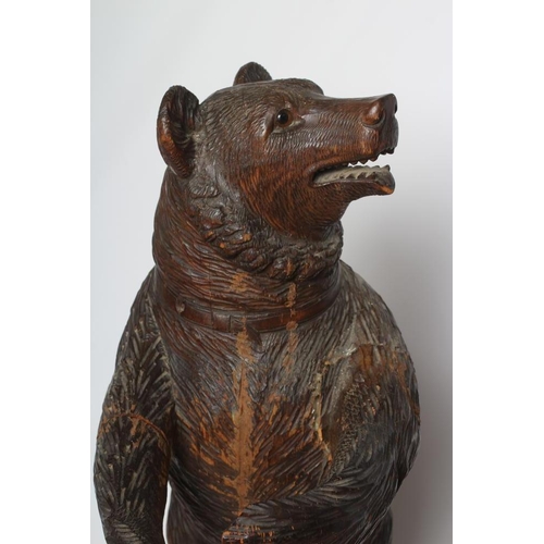 389 - A CARVED WOOD BLACK FOREST BEAR STICK STAND, modelled standing with its paws outstretched and head t... 