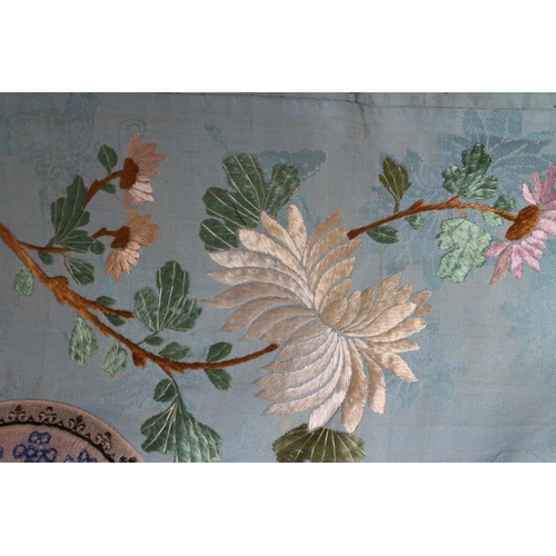 390 - A CHINESE SILK ROBE embroidered in coloured silks with flowers, the back centred by a roundel with a... 